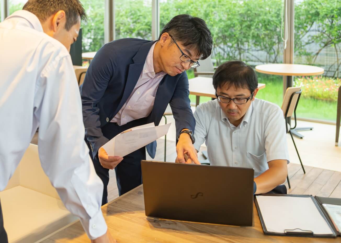 写真:兵藤寛昭社長と男性スタッフ二名が打ち合わせをしている様子